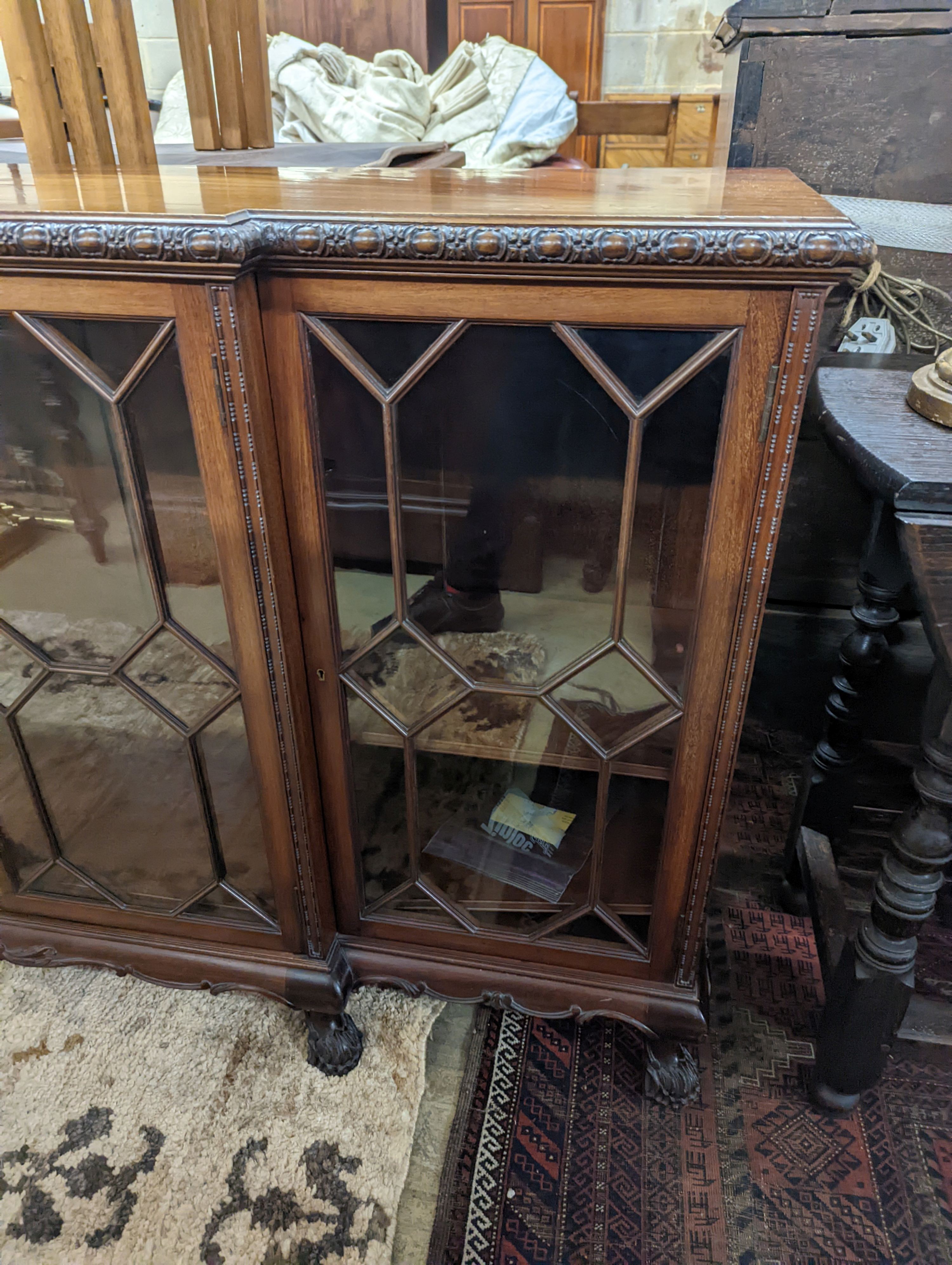 A 1920's Chippendale revival glazed mahogany break front dwarf cabinet, width 160cm, depth 43m, height 88cm